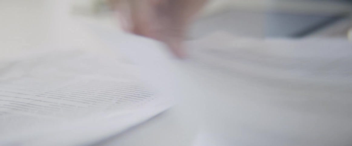 A woman going through papers on a desk in an office