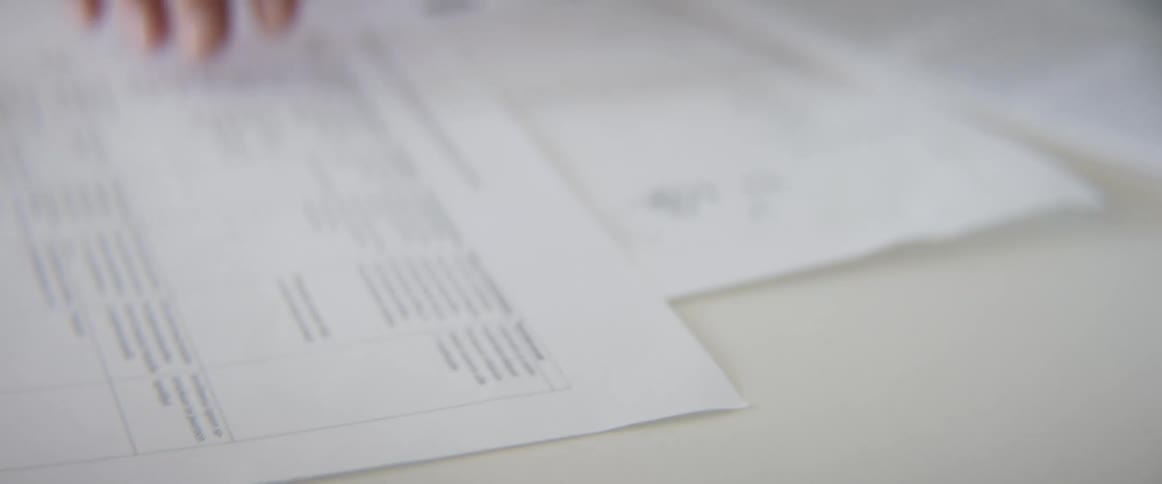 A woman going through papers on a desk in an office