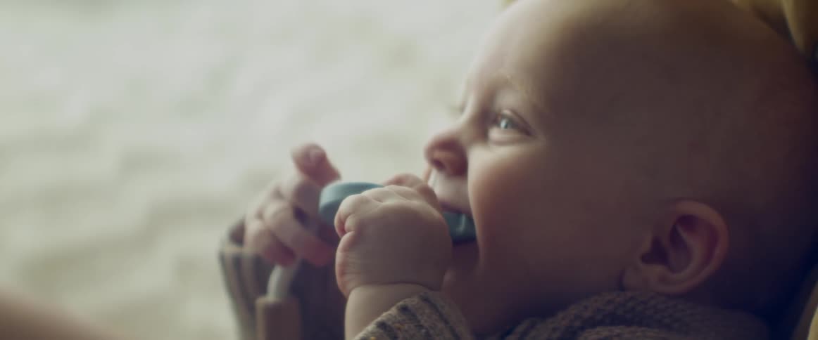 A baby is chewing on a toy
