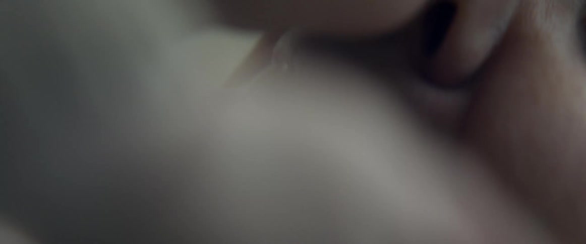 A woman lowers her baby down to her face and puts their noses together