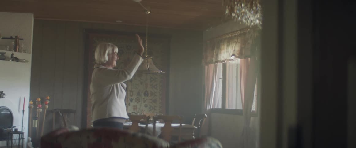 An elderly female caucasian waving out a window