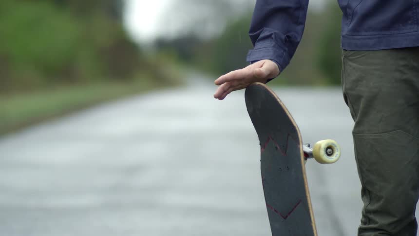 A person is twisting a skateboard in his hand