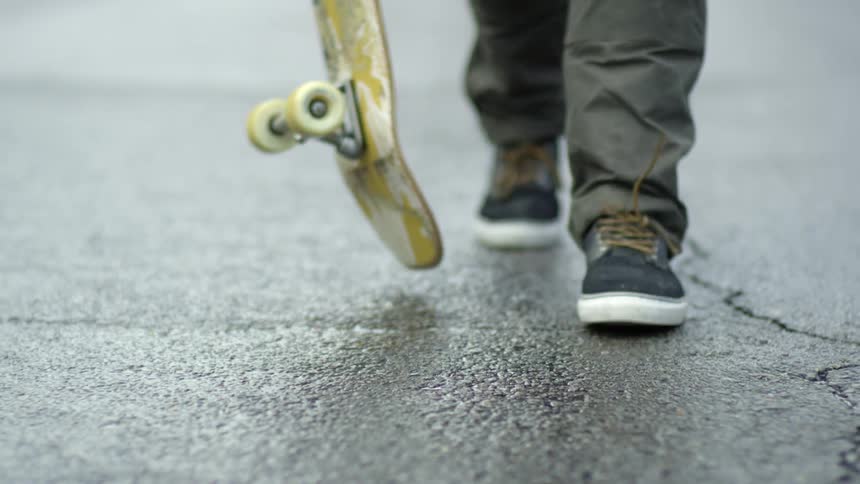 A person walking down a road with a skateboard