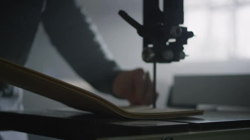 A man using a tabletop tool to cut wood