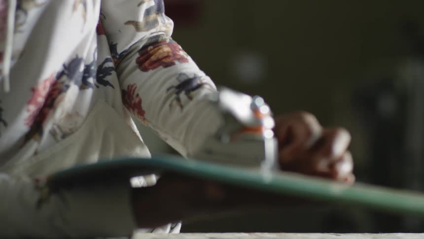 A person putting the wheel mechanism on the bottom of a skateboard