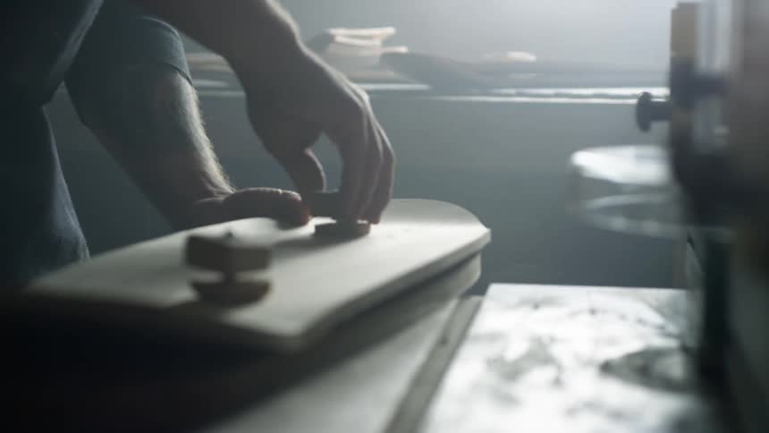 A man is putting a bolt into a board