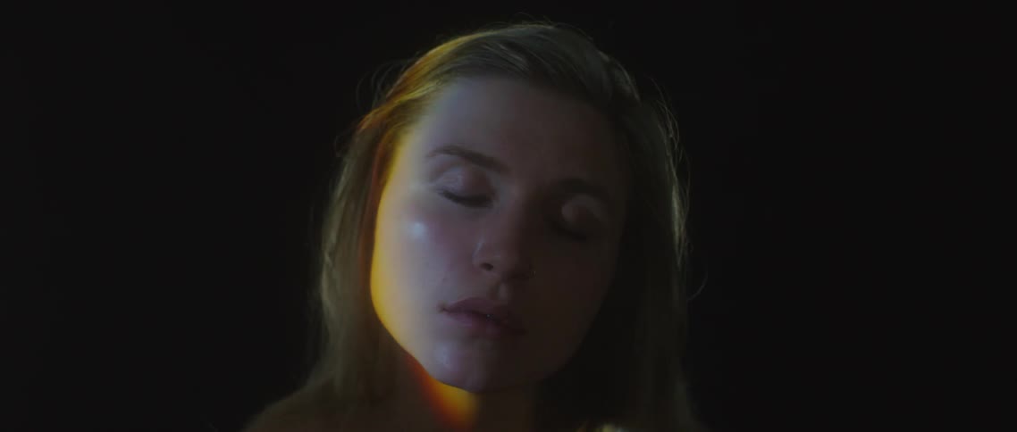 A woman standing while a light passes by her