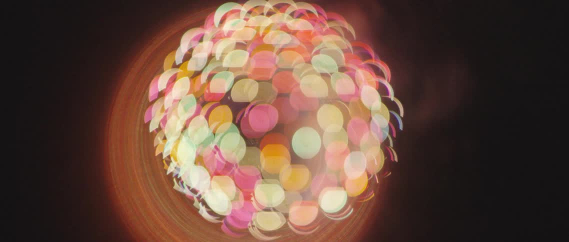 Lights in circular shapes receding and exploding in a colorful burst