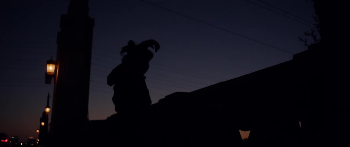 A woman dances outdoors against a dark purple sky at night