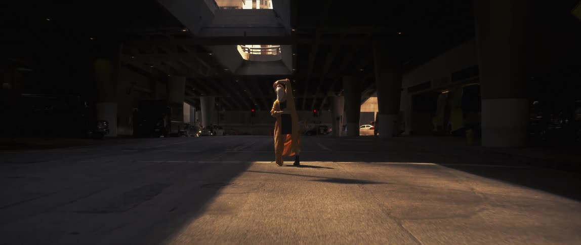 Woman dancing alone in the middle of a parking lot