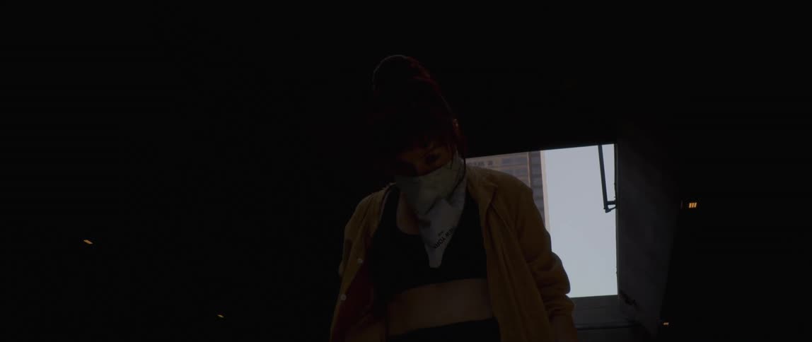 Woman with white mask and black tank top dances in dark room