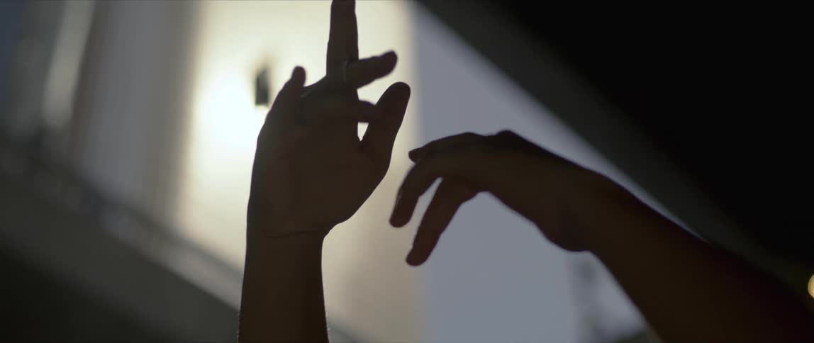 A woman reaching up into the sun
