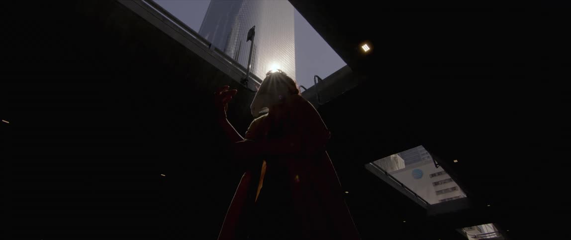 The silhouette of a woman dancing with a light glaring down off a building above