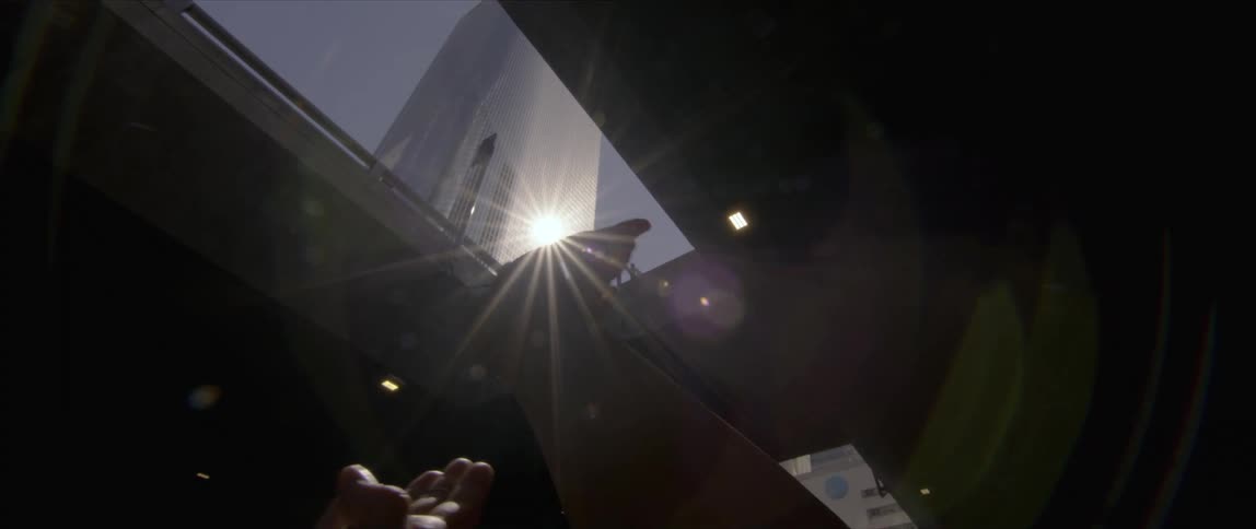 Woman hands waving and gesturing in front of the sunlight reflecting from a tall skyscraper
