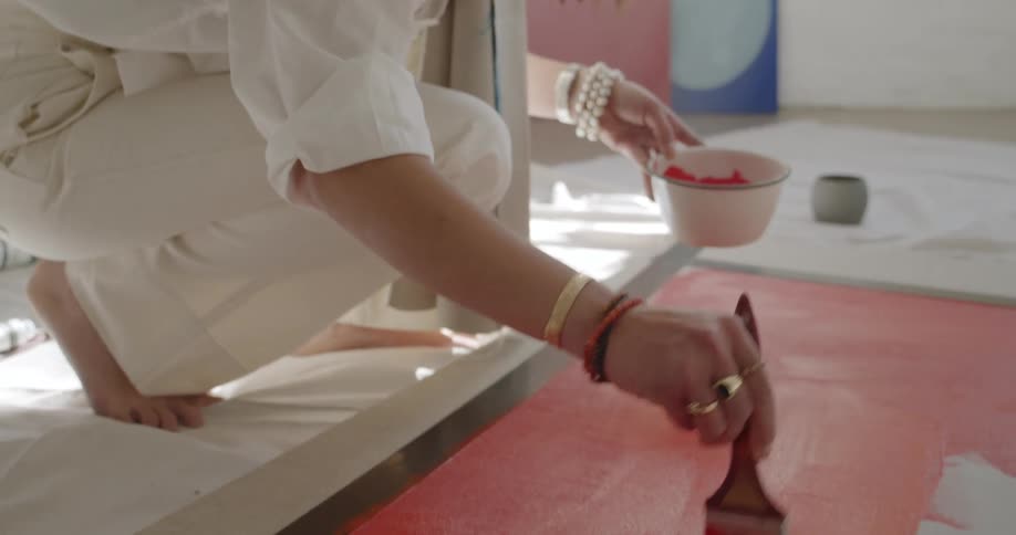 White woman painting with red ink