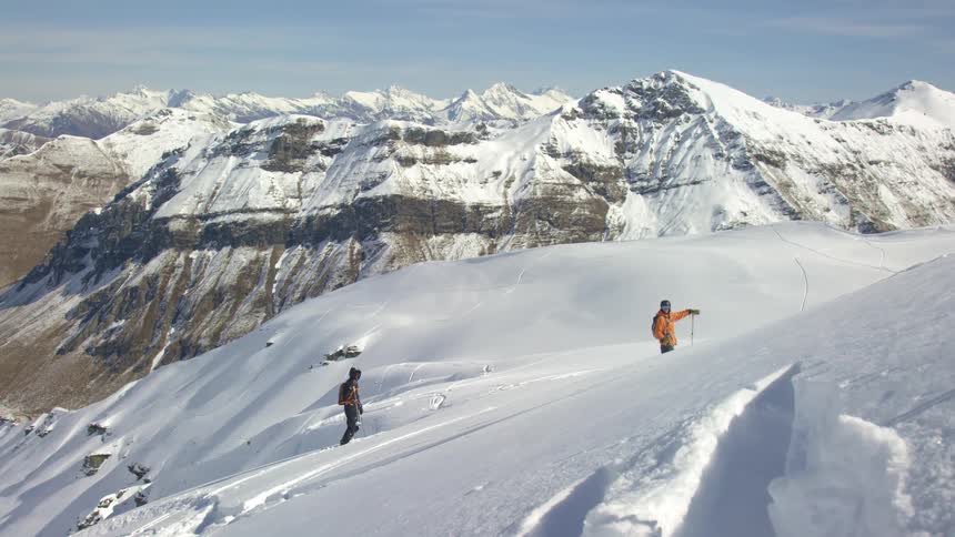Two people cross country skiing on snow covered mountains during the day