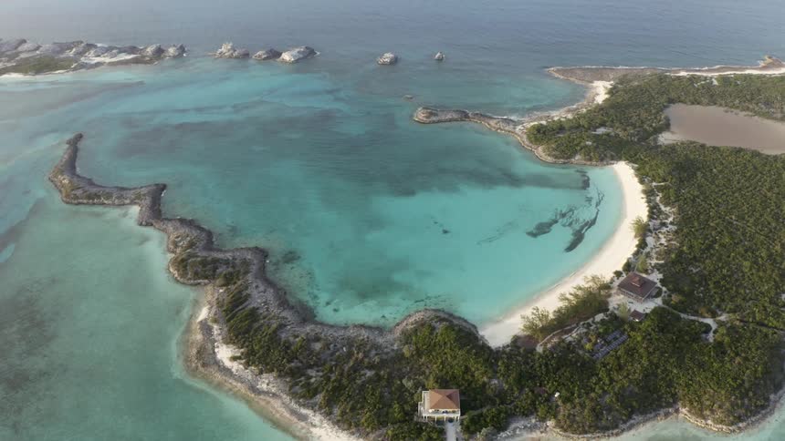 Aerial view of the coastline of a tropical island in the blue ocean waters