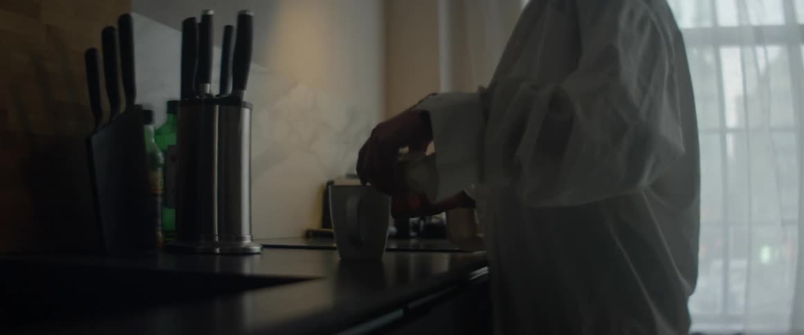 Young woman preparing a beverage in the kitchen at home