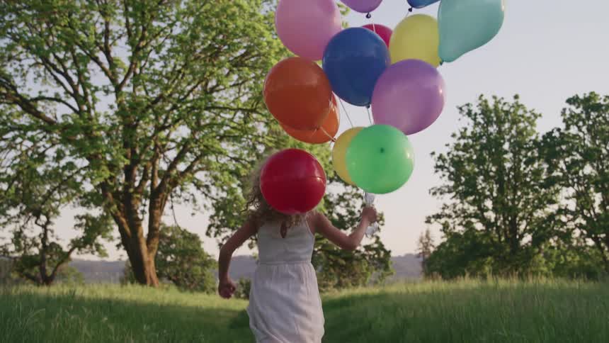A child holding balloons running