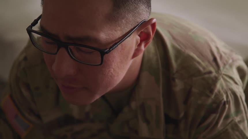 Close up of a male us soldier wearing glasses prone on the floor with eyes closed