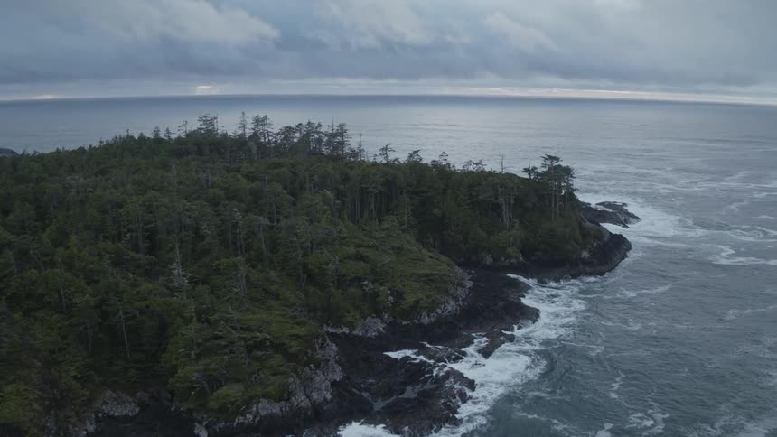 An aerial view of a rugged island covered in lush vegetation during a storm