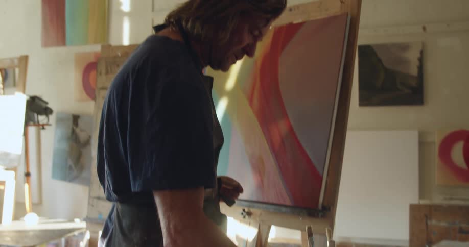 A painter cleans his brush in water