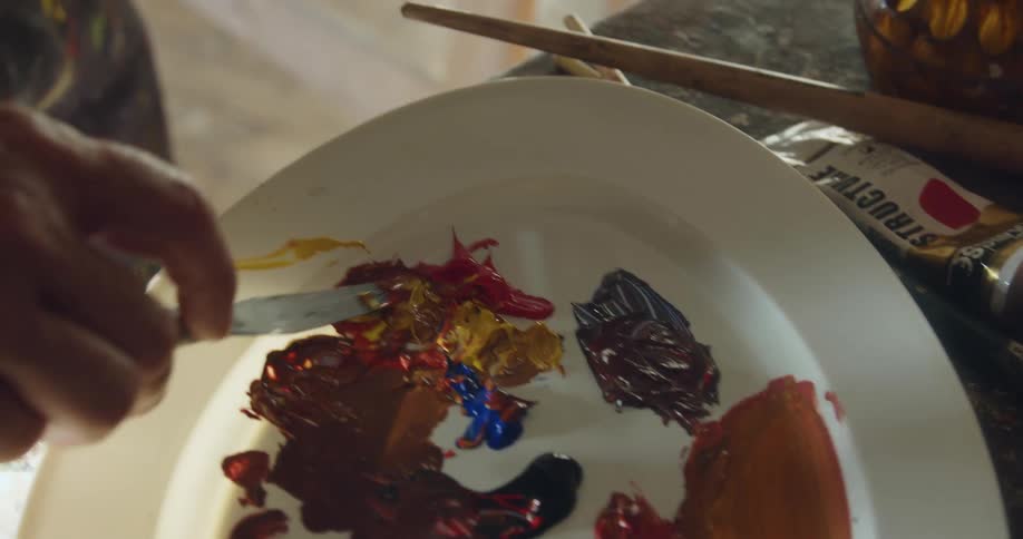 A painter is mixing paint together