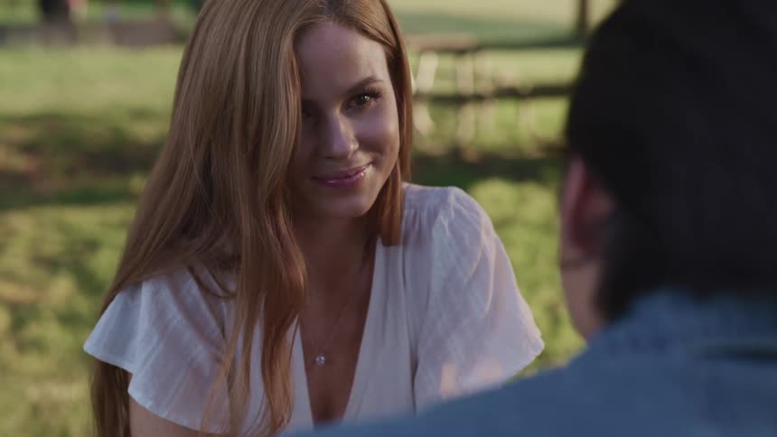 A caucasian woman looking up and smiling at a man in front of her