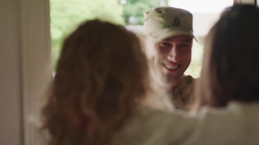 Soldier returning home greeted with hugs by his family at the door