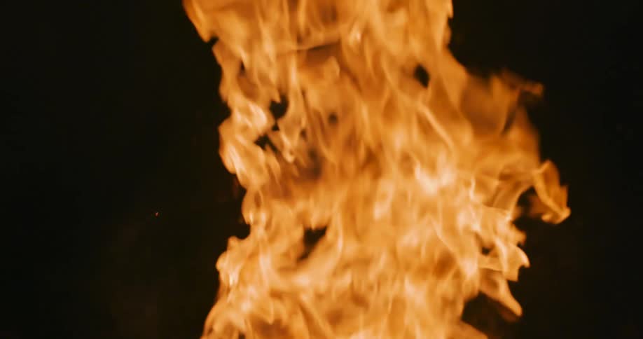 Flames rising from branches outdoors at night