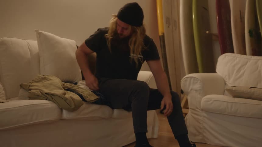 A man putting on shoes then standing up