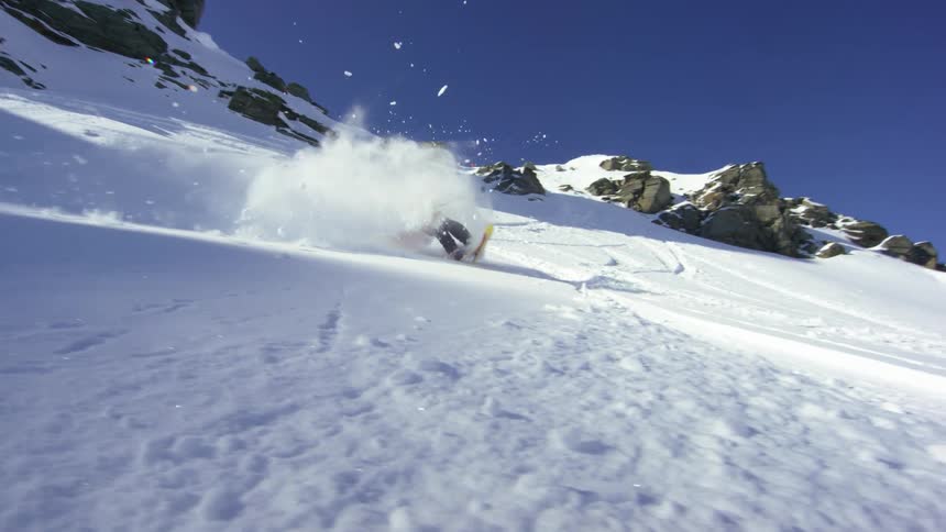 Skier sliding down the snow covered slopes of a mountain range