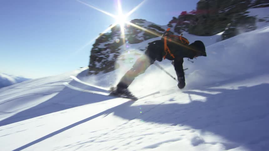 Person skiing down mountain and doing a stunt on a clear day