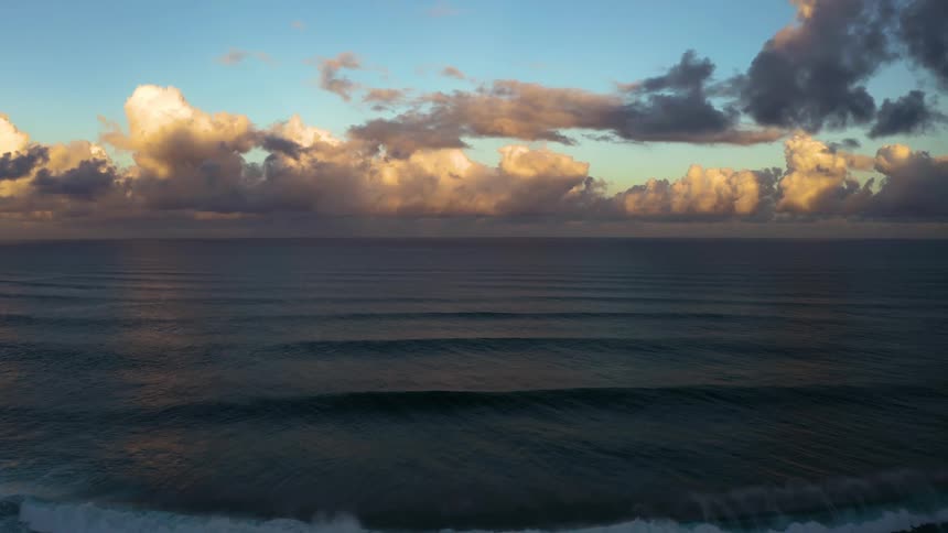 Waves rolling in on the coast and a cloud filled sky