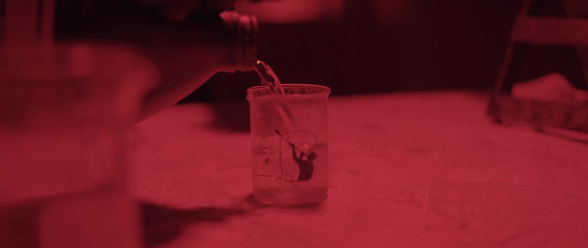 Pouring an unknown liquid into another glass