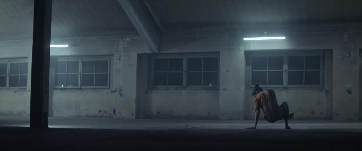 A woman in a room dancing with lights and windows in the background