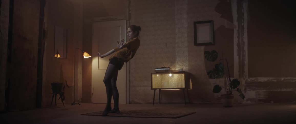 A woman performs a dance routine in a room