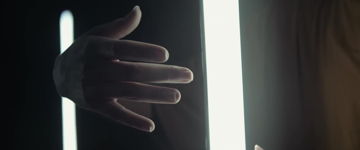 A person moves hands around a light source while standing indoors