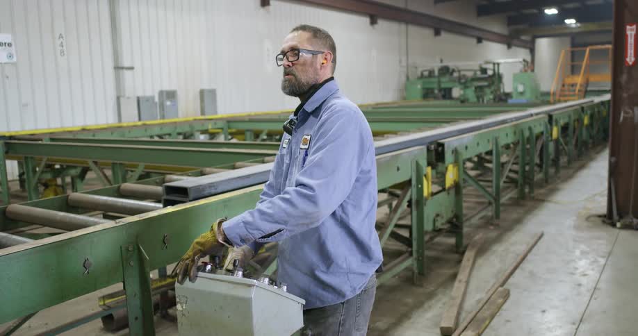 A man is operating controls for a conveyor machine