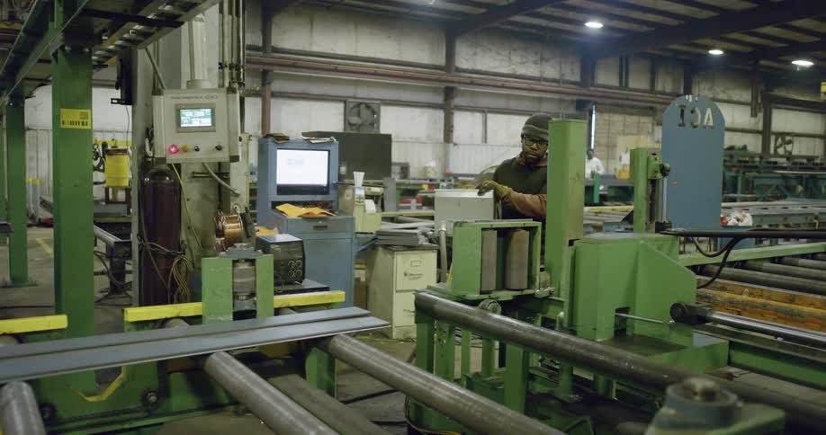 Men working in a steel factory full of machinery