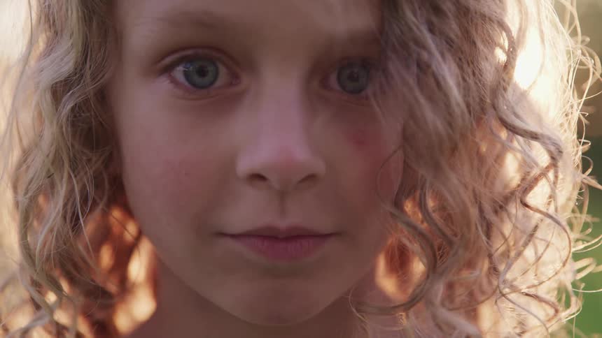 A girl stares forward on a sunny day