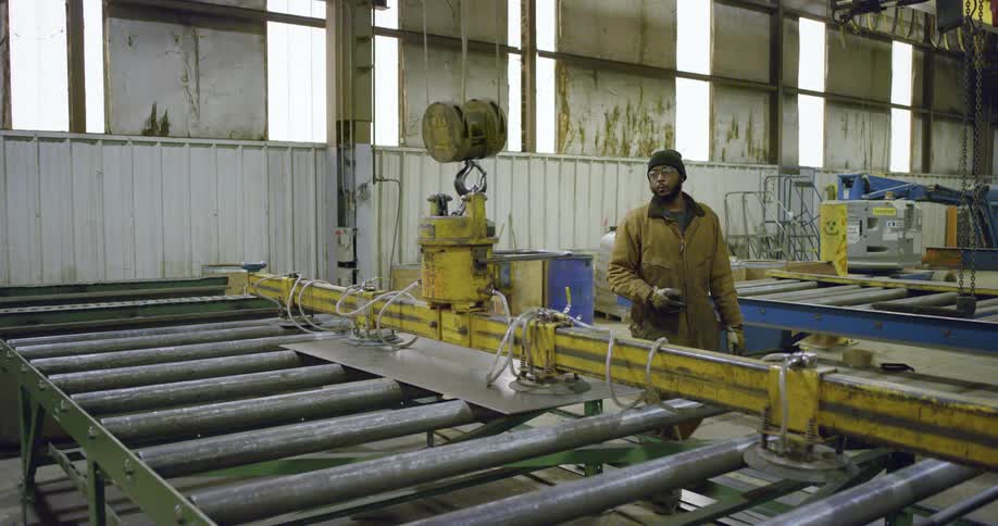A man working with a small crane in a factory