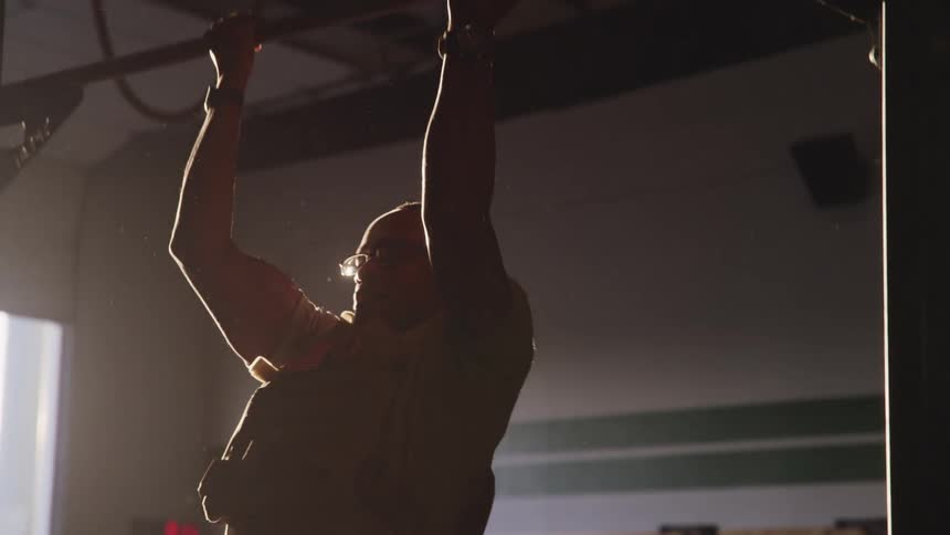 Man doing pullups at the bar in an empty room