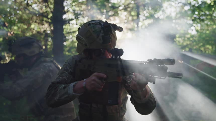 Three military soldiers with their guns at the ready scoping for movement in a forest