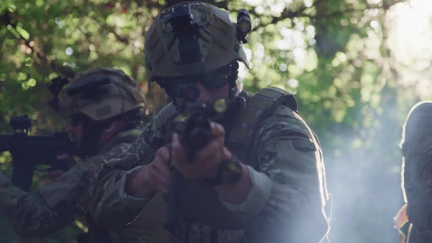Soldiers in a forest pointing their guns