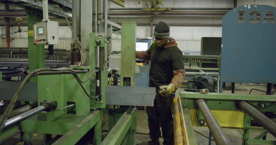 A man hammers on steel in a factory