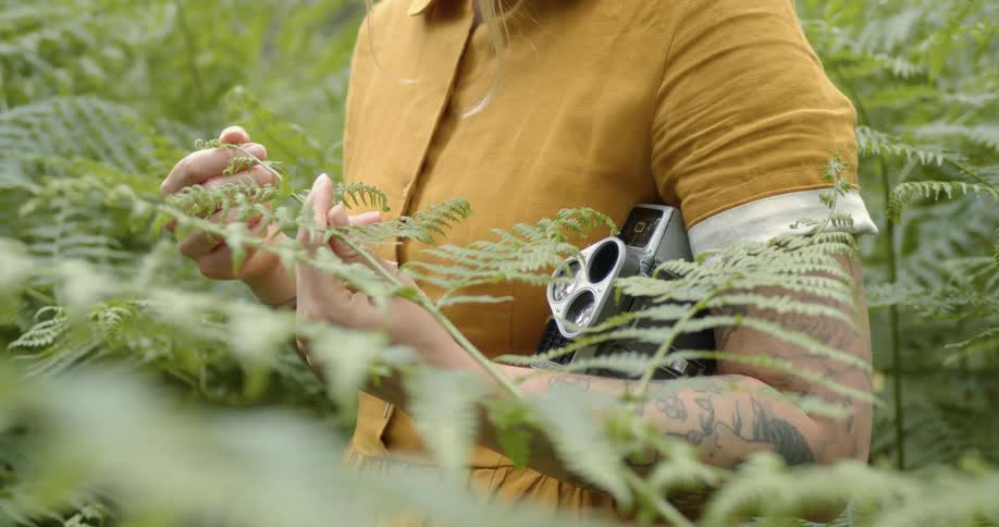 A woman holding a plant and a camera