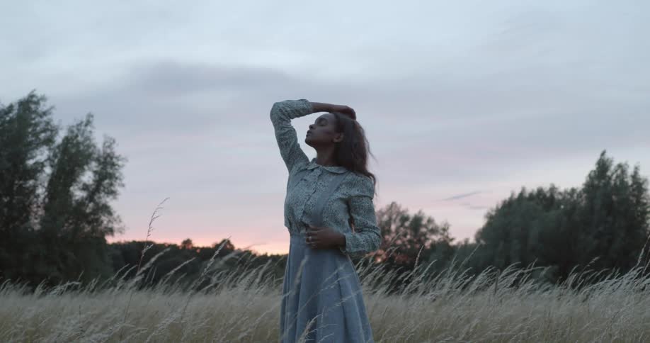 Woman posing for a photo shoot in the middle of the grass field
