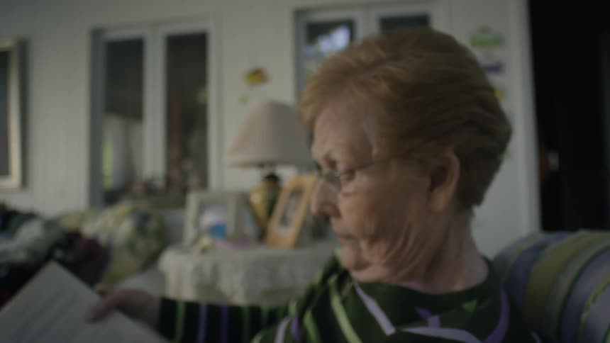 A woman is sitting on a couch reading a book
