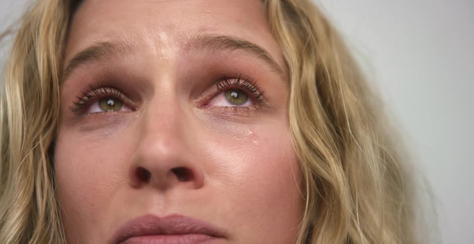 White woman crying alone with tear drops falling down her face